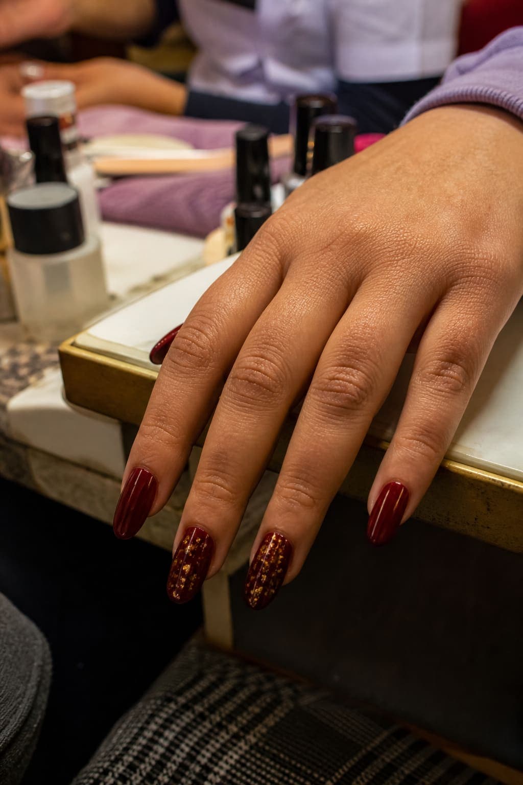 Burgundy acrylic nails with gold foil accents